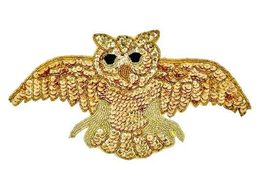 Gold owl-shaped decorative patch on a white background