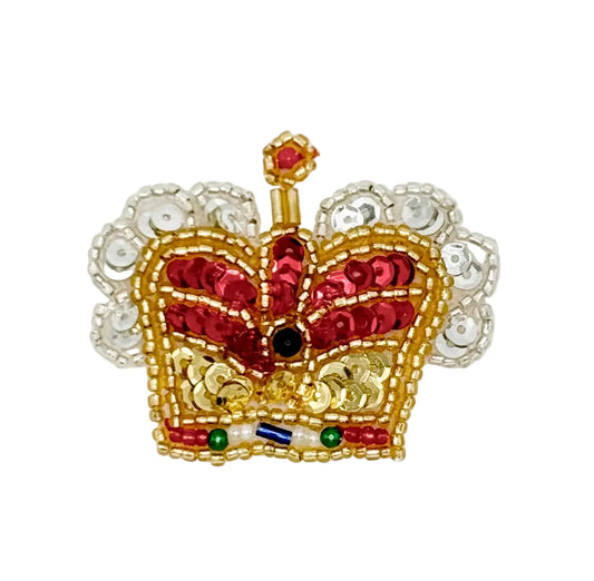 Decorative crown with red and gold sequins and beads on a white background