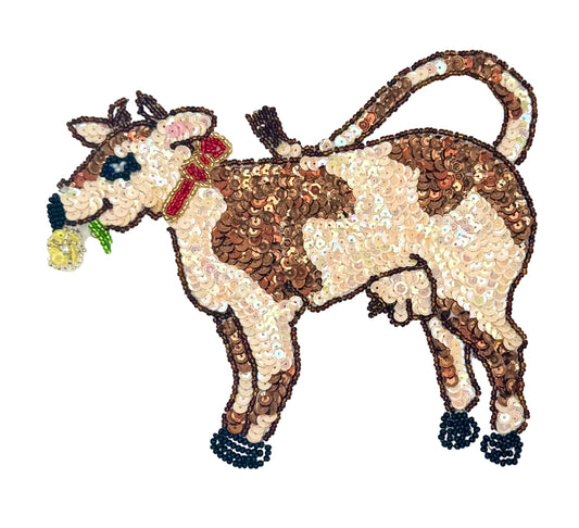 Decorative cow patch with sequins and beads on a white background