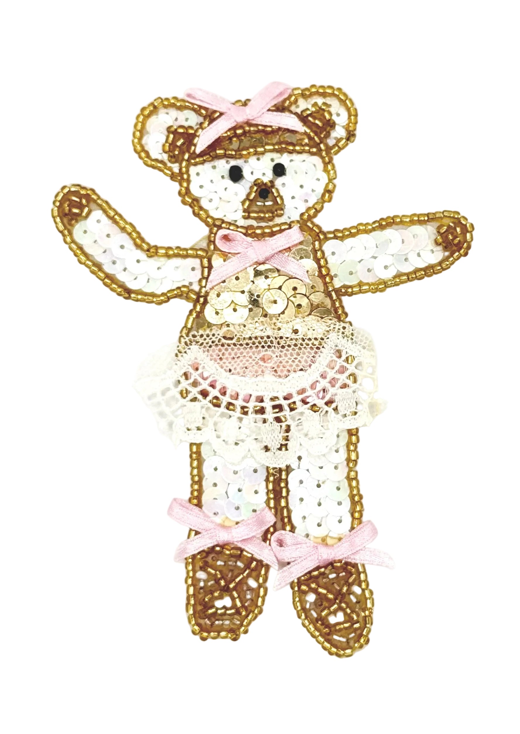 Decorative teddy bear in a tutu and ballet slippers with gold sequins and pink ribbons on a white background