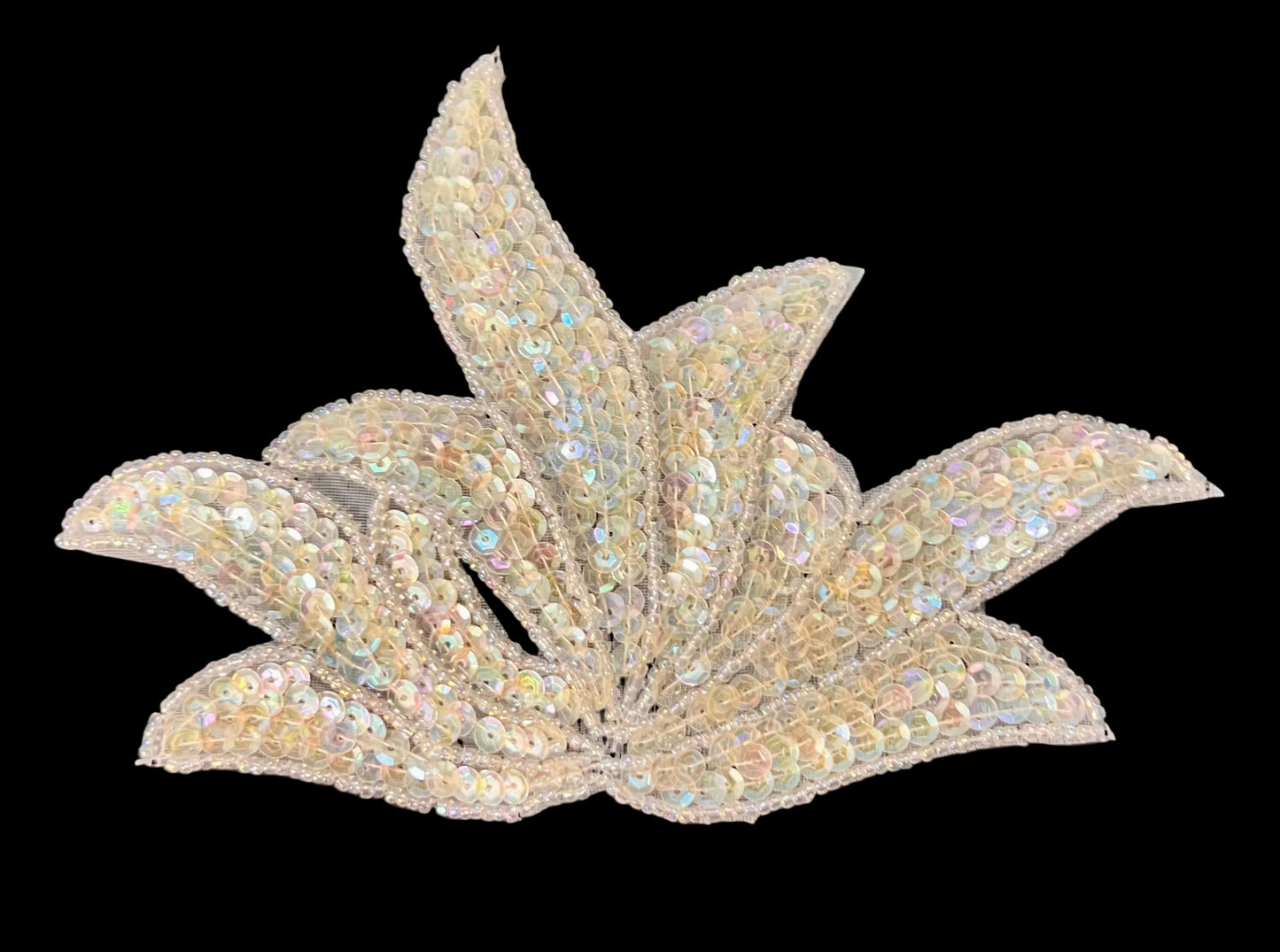 Decorative leaf-shaped embellishment with sequins on a dark background