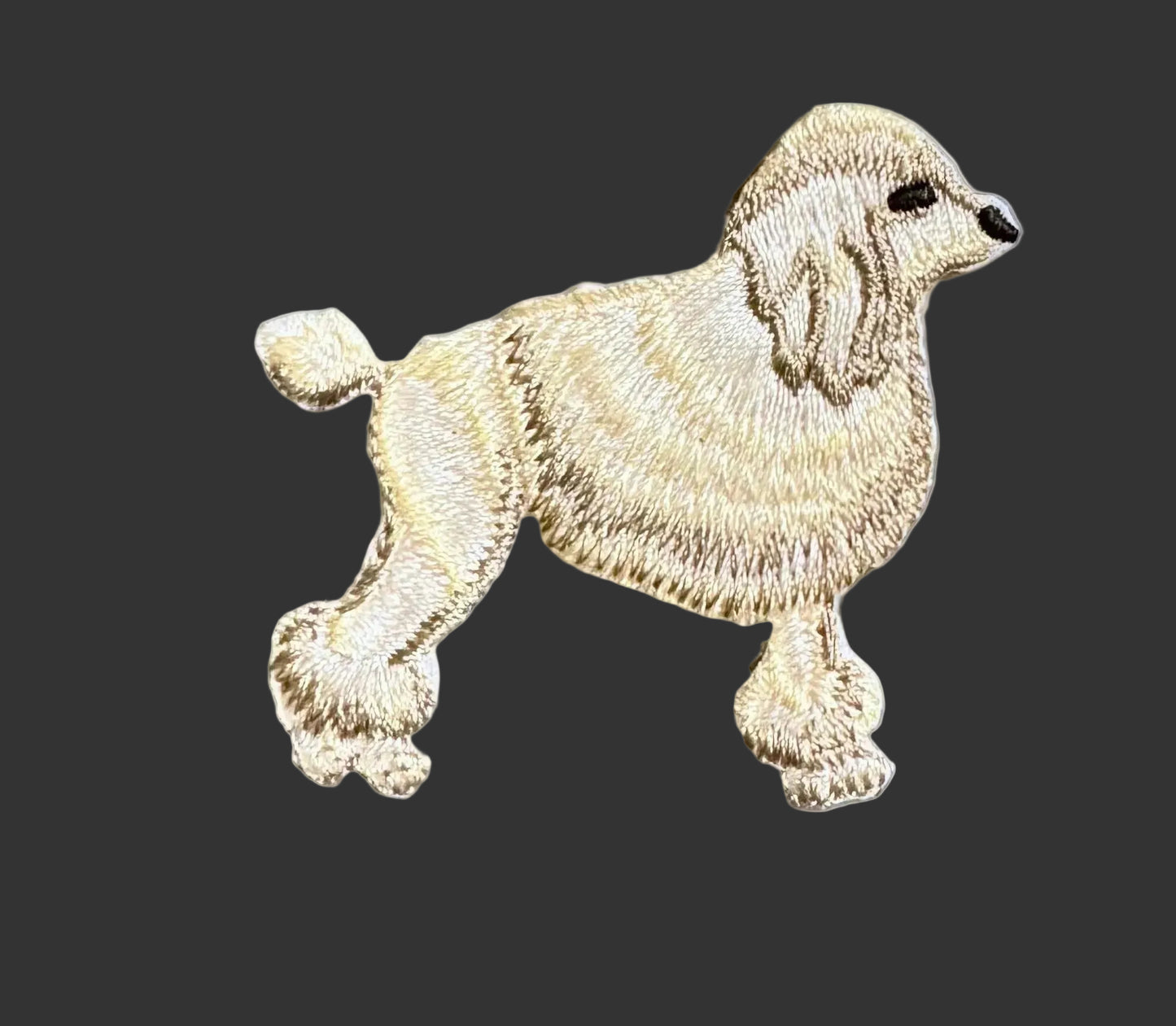 Embroidered poodle design on a black background