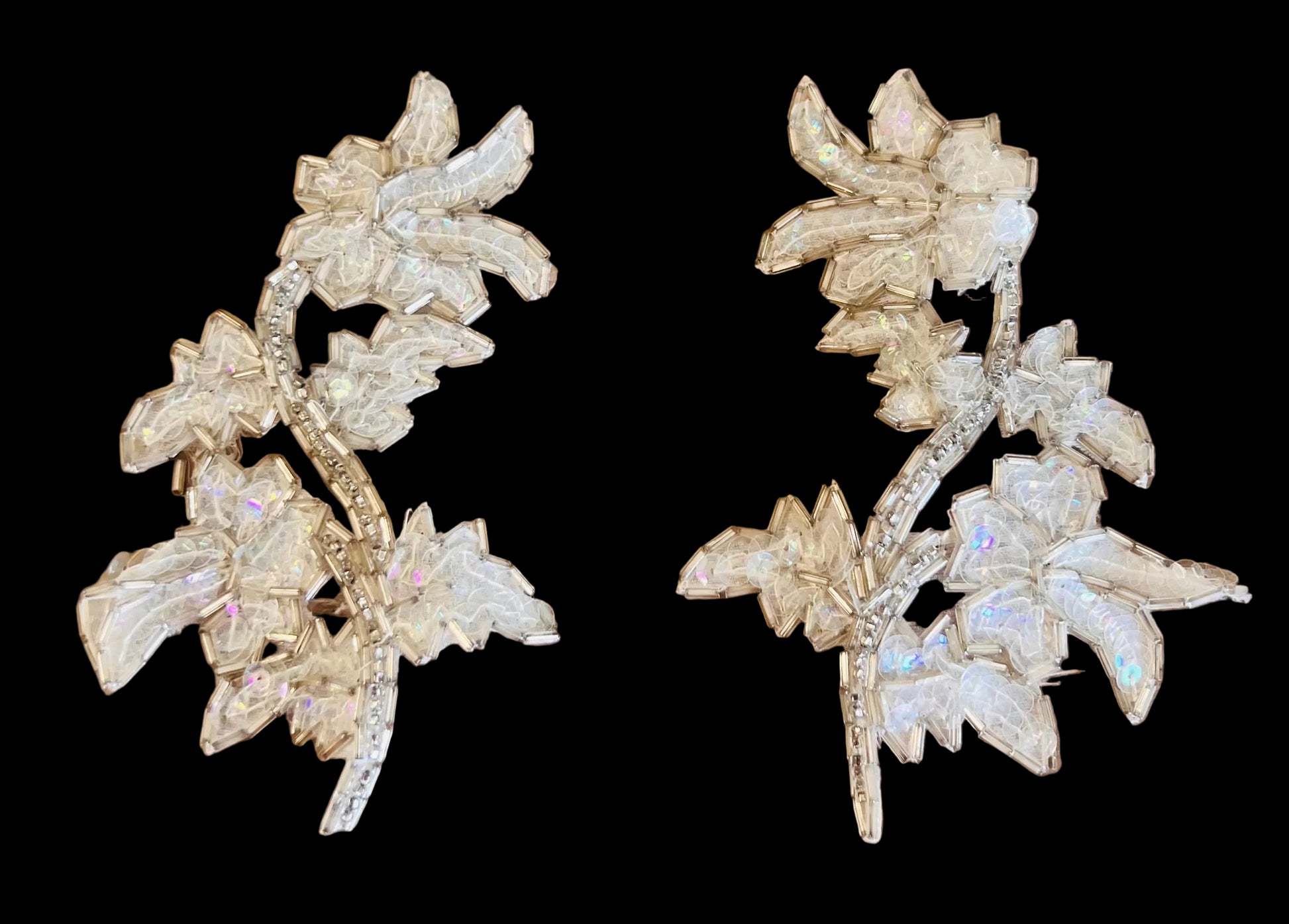 Pair of floral patches  sequins and beads on a dark background