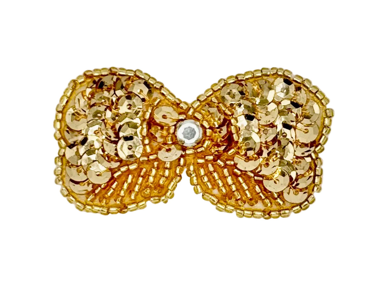 Gold bow with sequins and beads with a central grhinestone on a white background