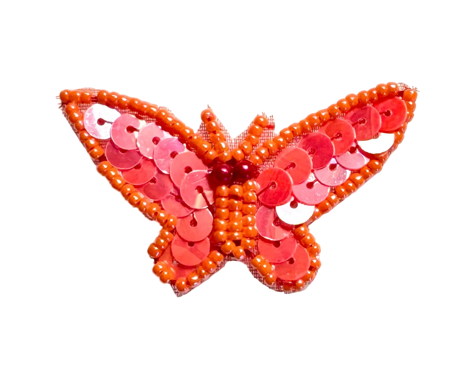 Butterfly-shaped decorative item with iridescent orange sequins on a white background