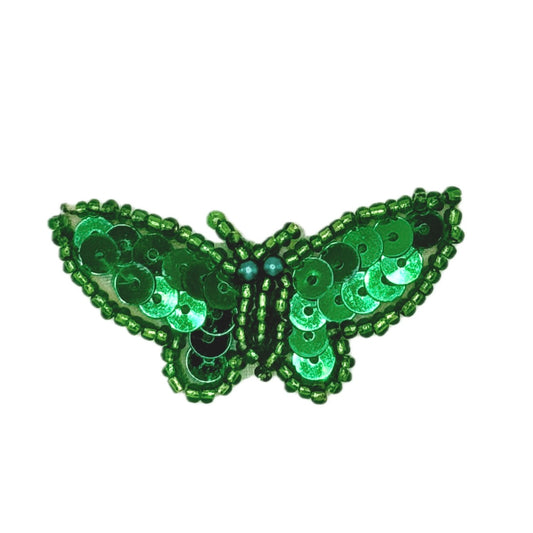 Green butterfly-shaped decorative item with sequins on a white background
