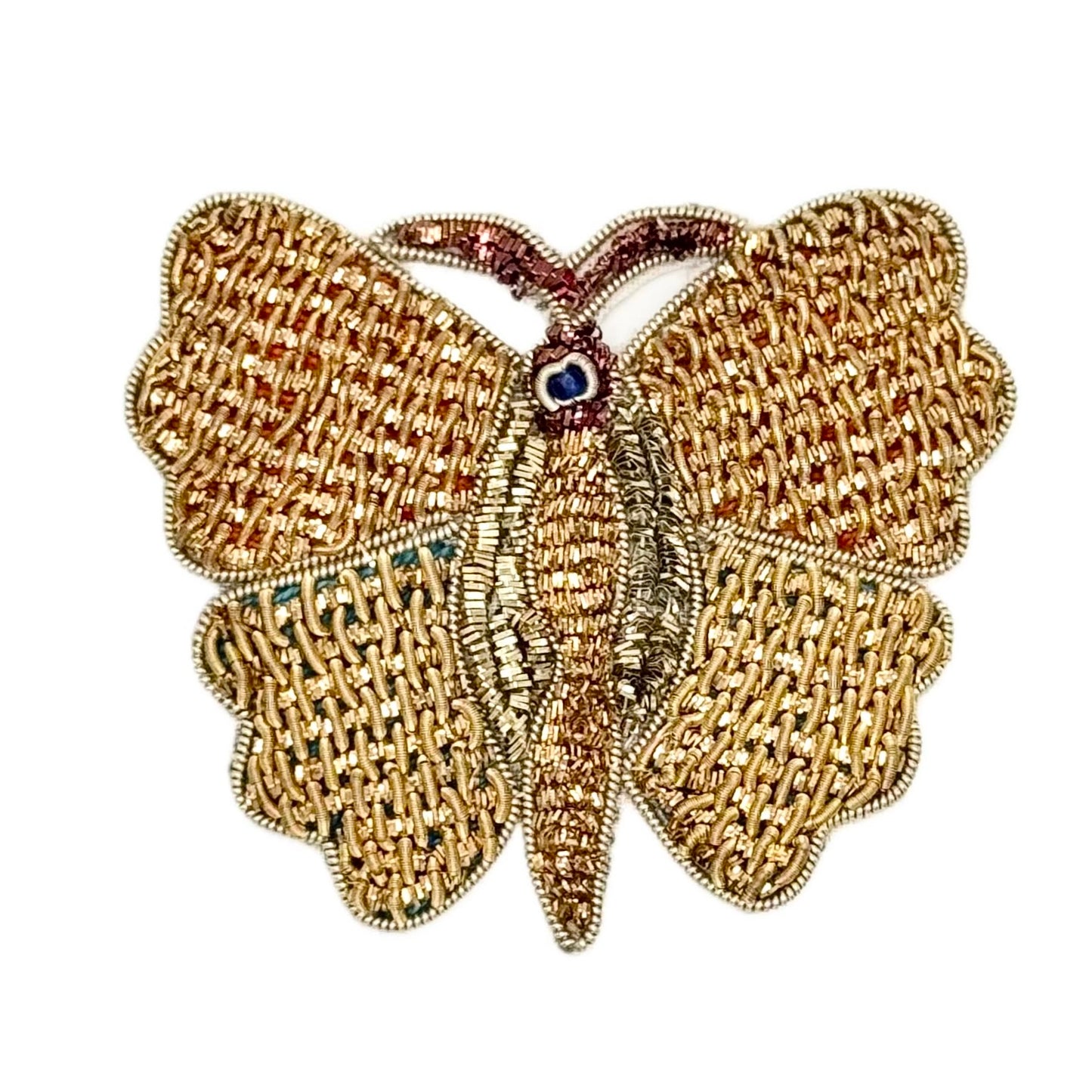Gold butterfly-shaped patch with Bronze details and  with a central gemstone on a white background