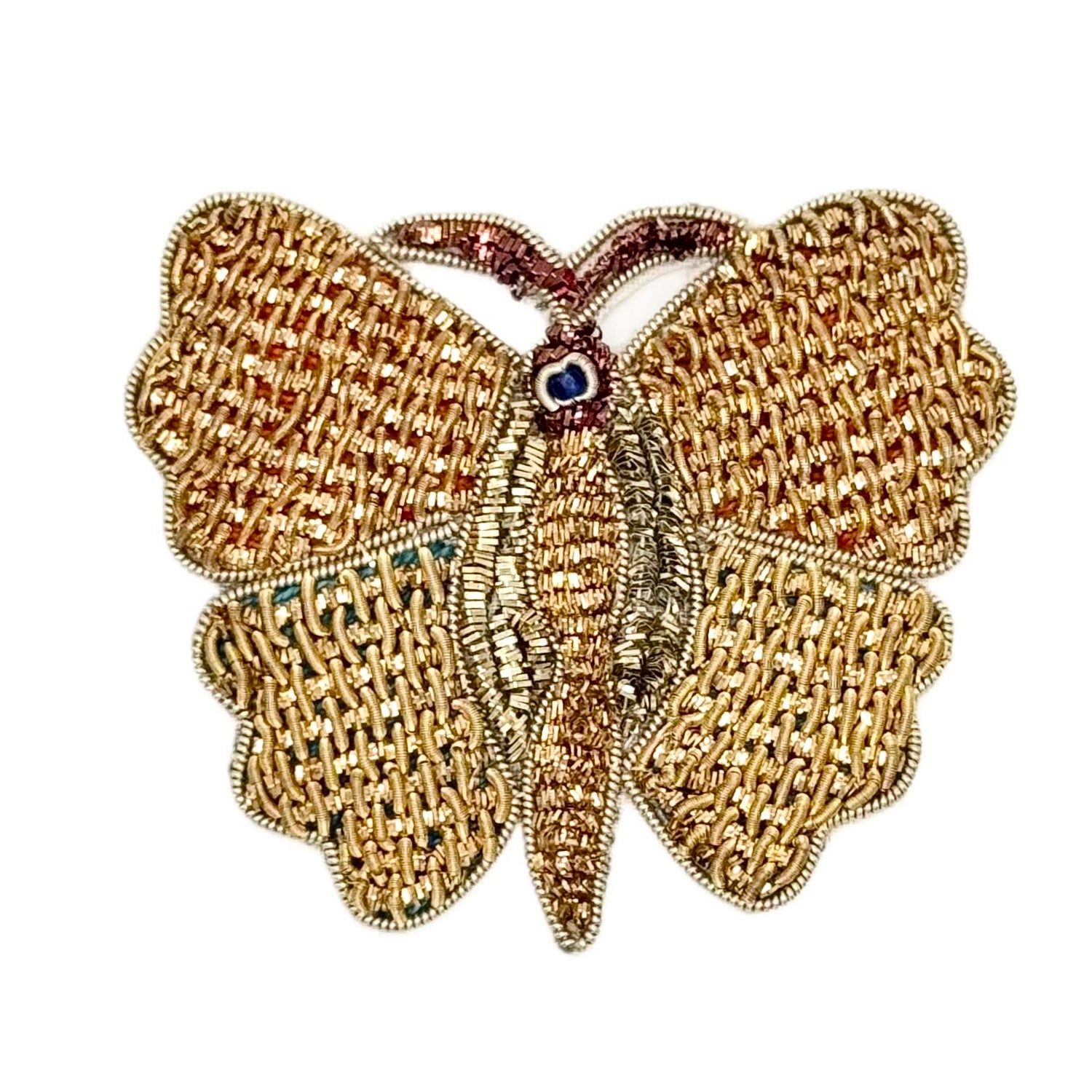 Gold butterfly-shaped patch with Bronze details and  with a central gemstone on a white background