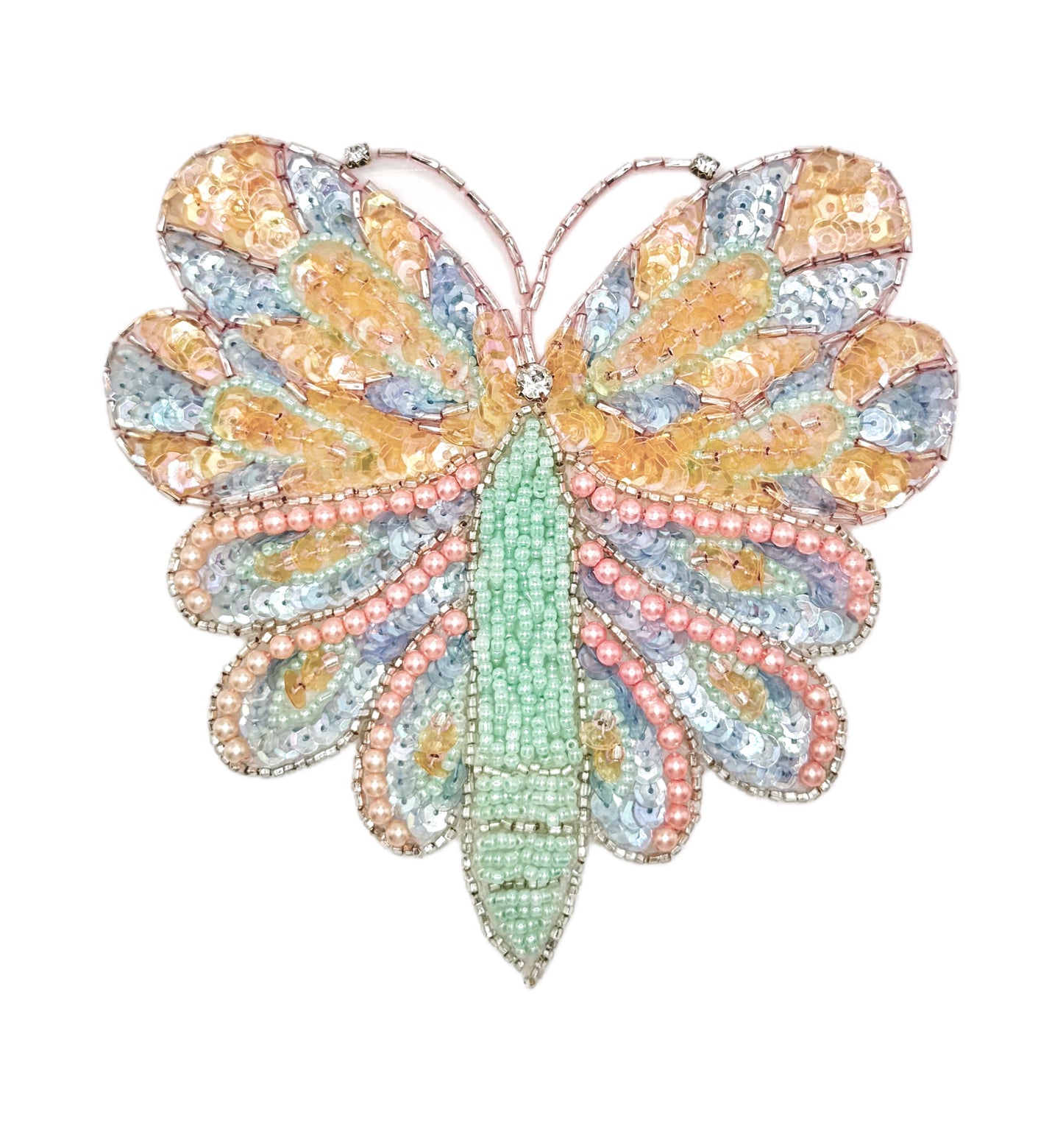 Butterfly-shaped decorative item with multicolored pastel sequins and beads on a white background