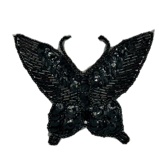 Black butterfly-shaped patch with sequins on a white background
