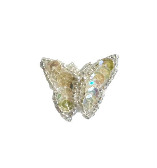 Butterfly-shaped patch with iridescent sequins and beads on a white background
