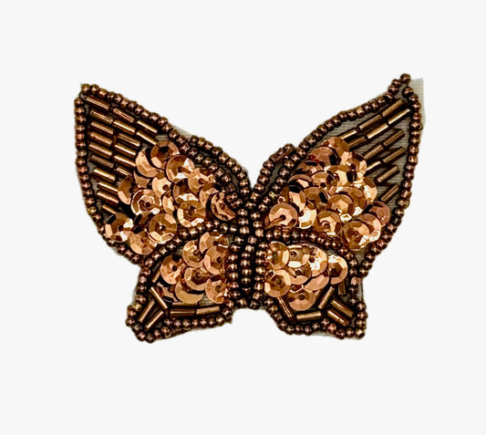 Decorative butterfly with bronze sequin details on a white background