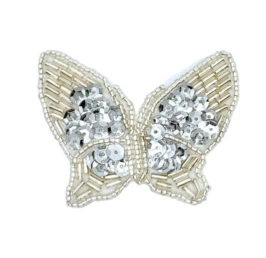 Butterfly-shaped decorative item with silver sequins on a white background