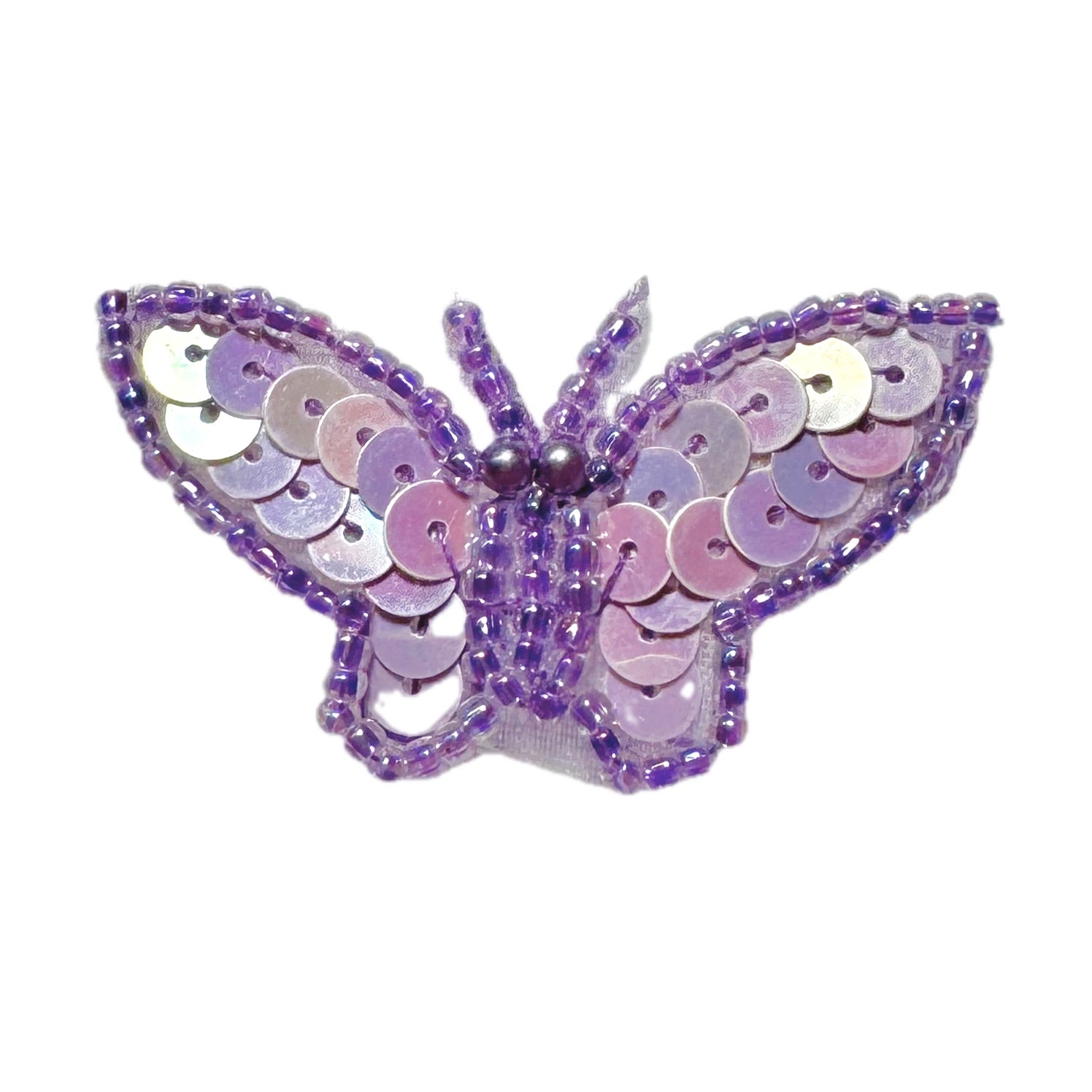 Butterfly-shaped decorative item with purple and pink sequins on a white background