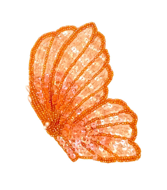 Sequined butterfly flying on a white background