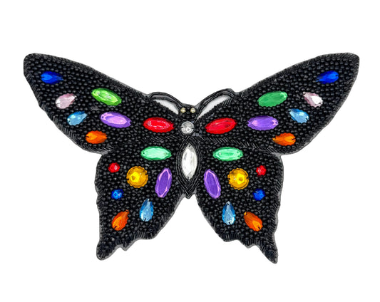 Butterfly-shaped patch with colorful gemstones on a white background