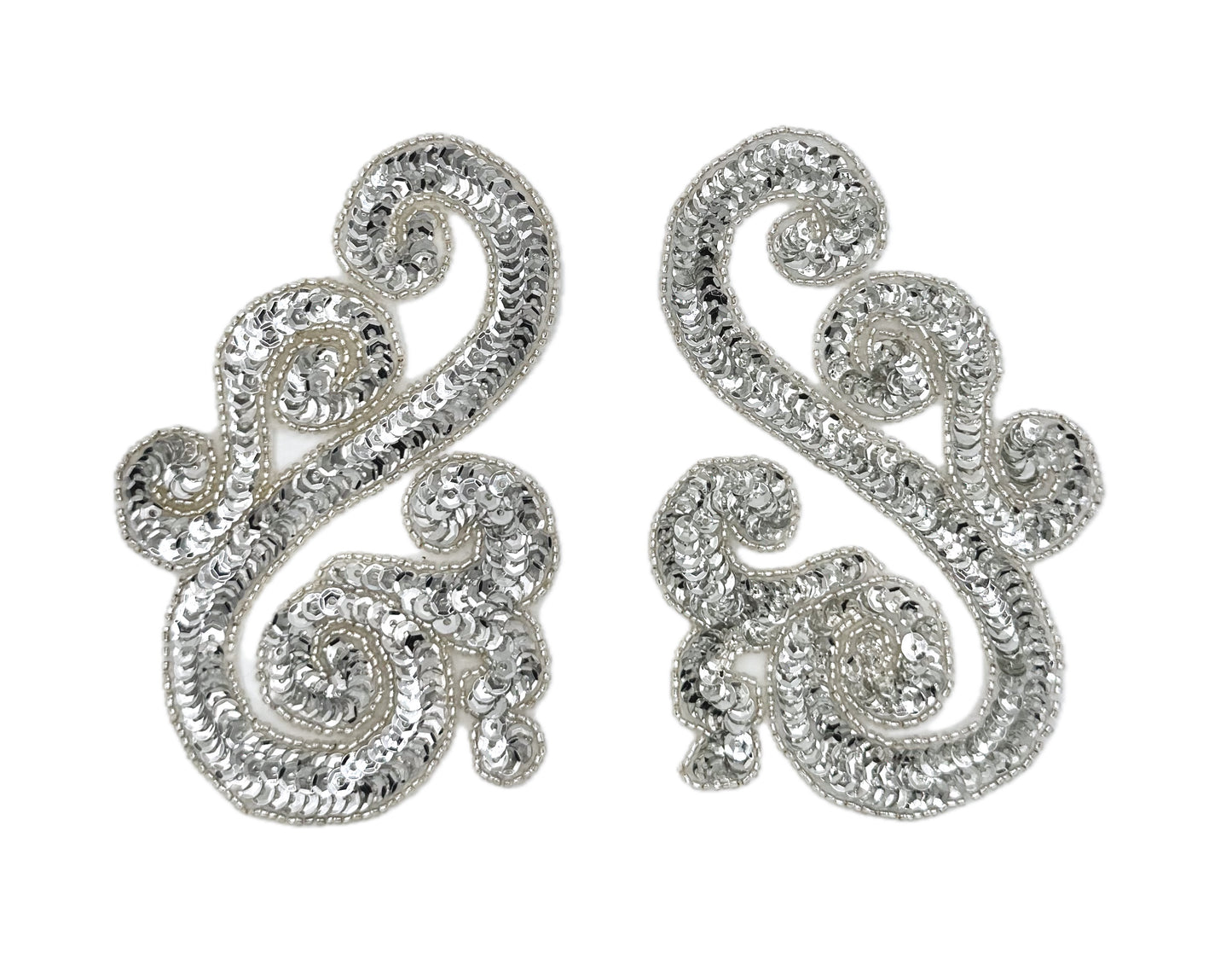 Silver sequin and bead accent pairs with intricate designs on a white background