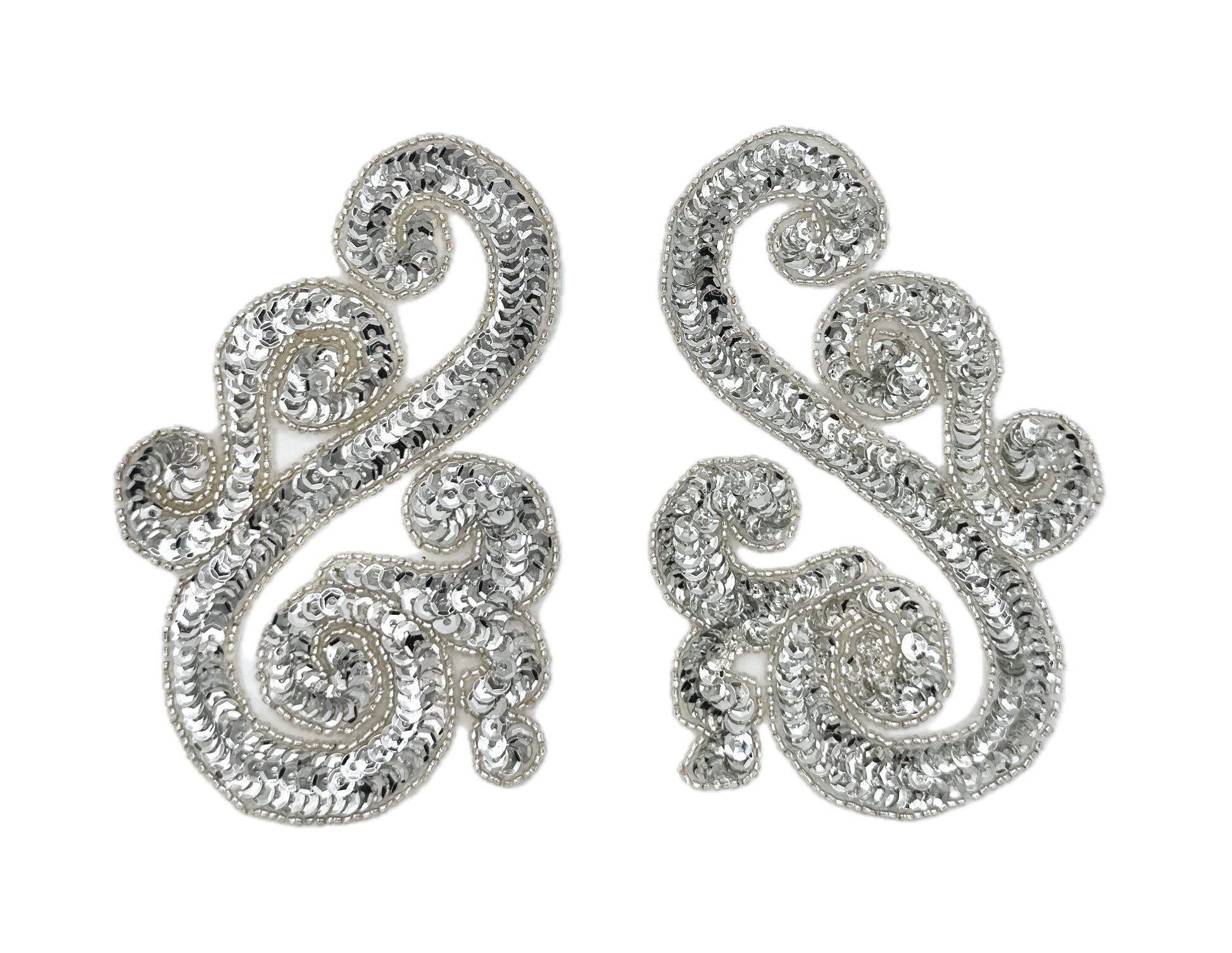Silver sequin and bead accent pairs with intricate designs on a white background