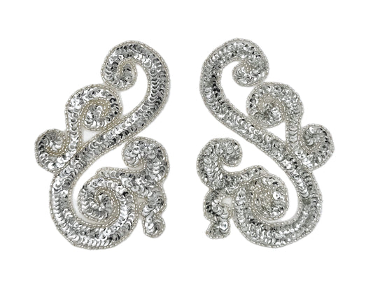Silver sequin and bead accent pairs with intricate designs on a white background