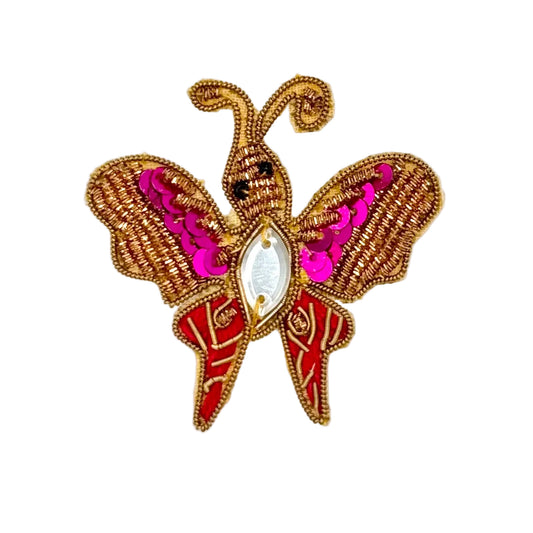 Butterfly-shaped embroidered patch with gold, red, and pink details on a white background