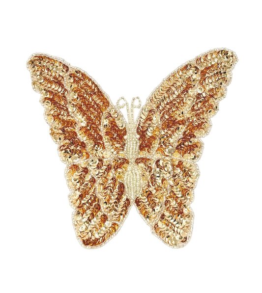Gold butterfly-shaped patch with sequins on a white background