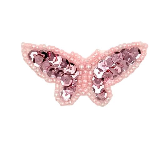 Butterfly-shaped patch with pink sequins and beads on a white background