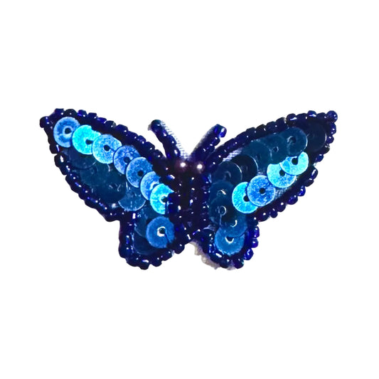 Blue butterfly with sequin details on a white background
