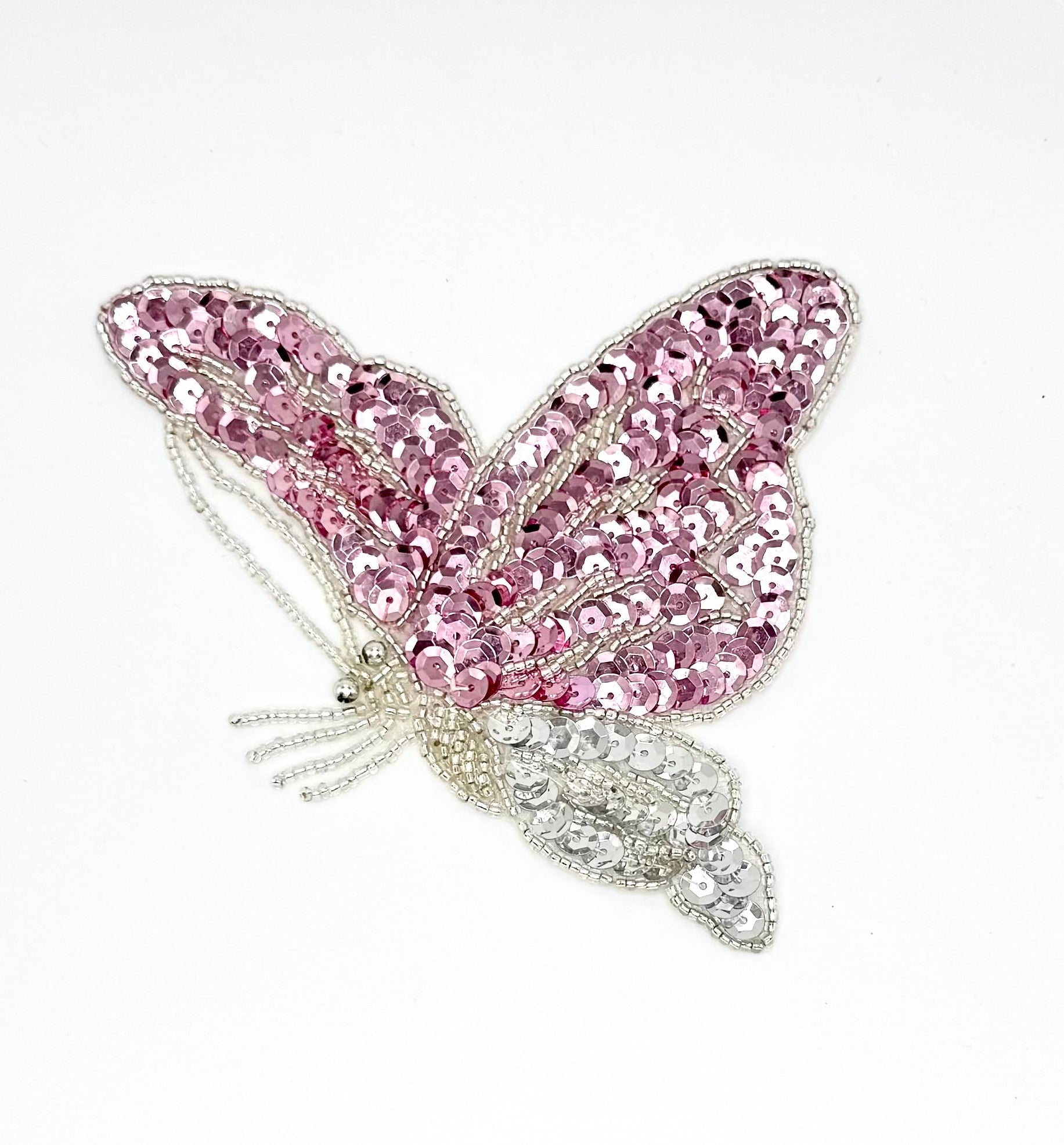Pink butterfly patch  with sequins and beads on a white background