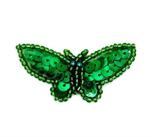 Green butterfly-shaped decorative item with sequins on a white background