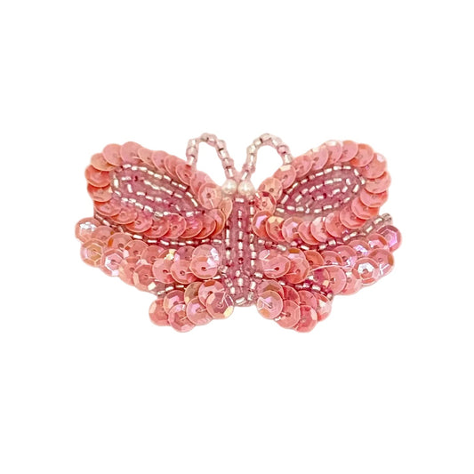 Pink butterfly-shaped decorative item with sequins on a white background