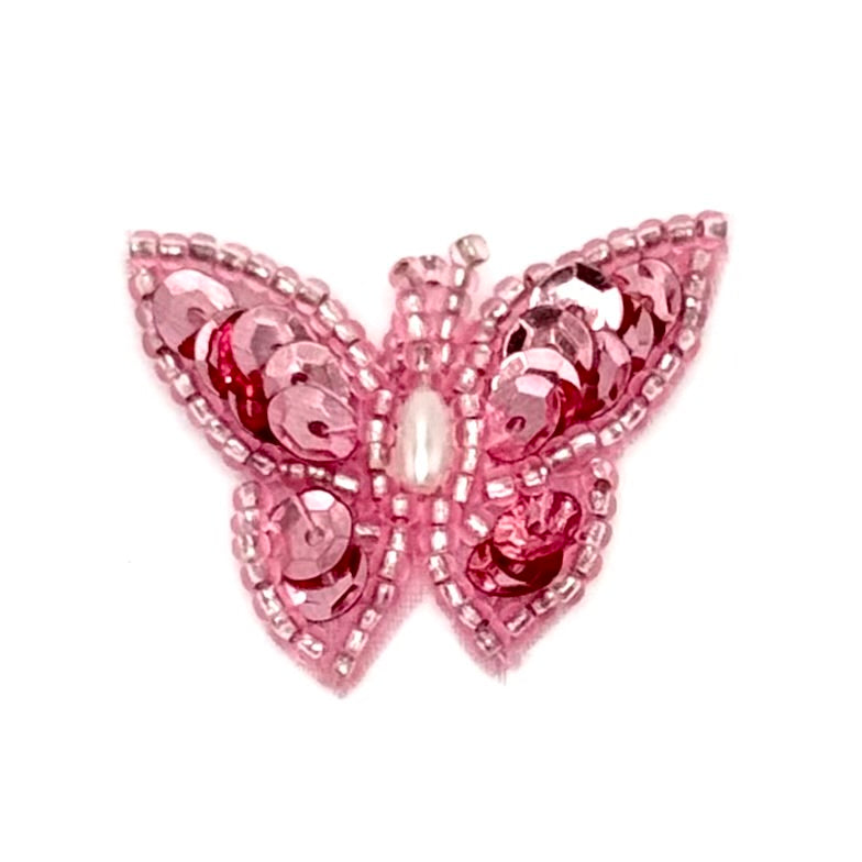 Pink butterfly decorative item with sequins on a white background