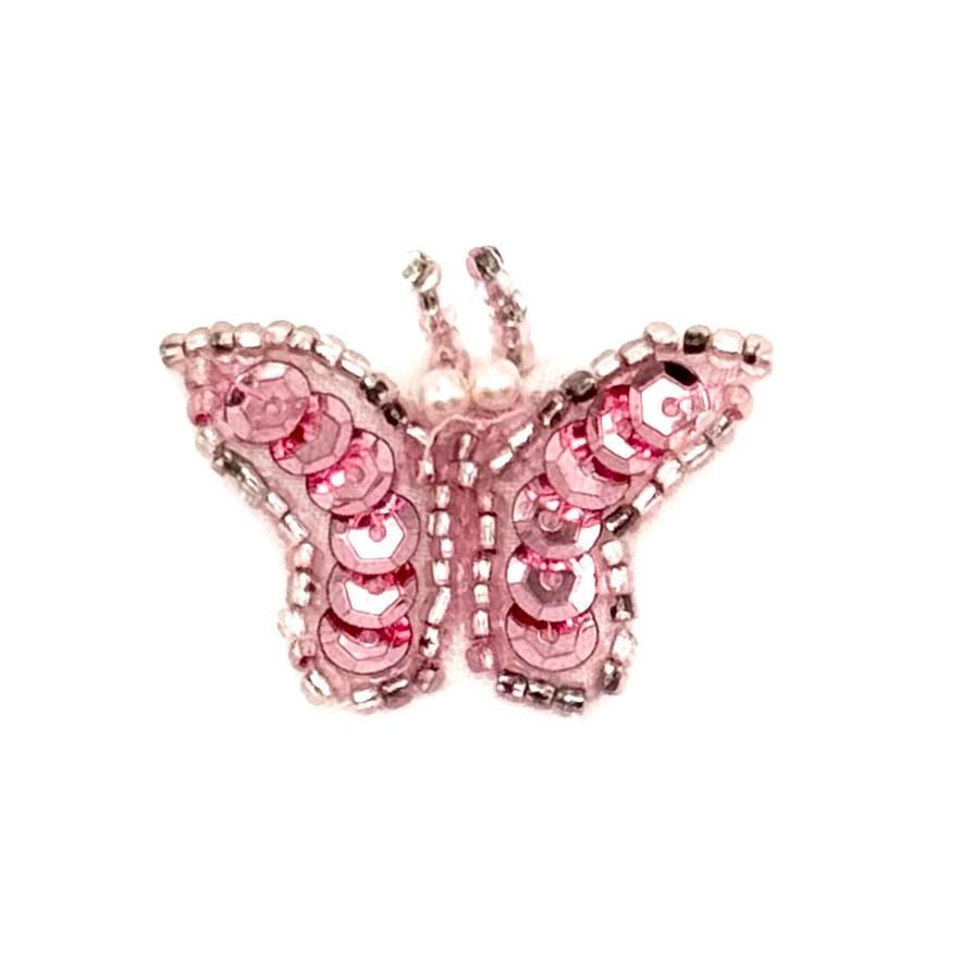 Pink butterfly decorative item with sequins on a white background