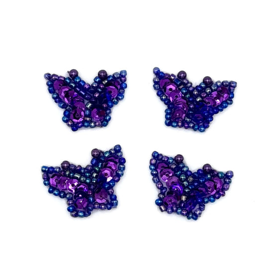 Four purple butterfly-shaped patch made of sequins beads on a white background