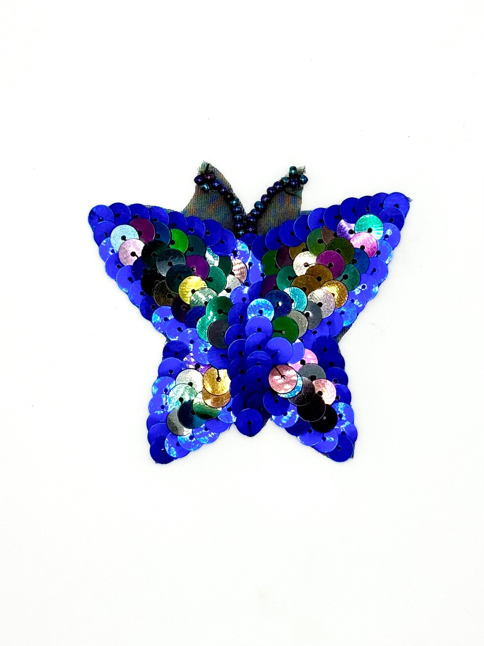Butterfly-shaped patch with sequins on a white background