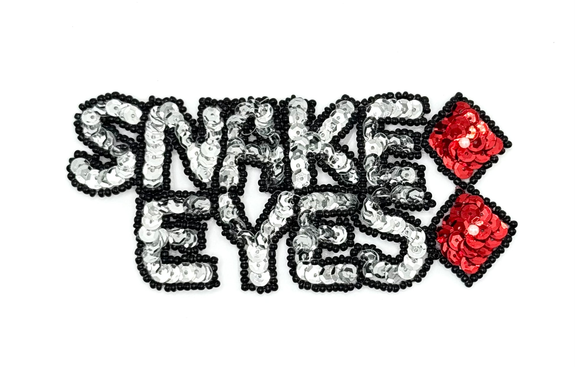 The words Snake Eyes in sequins and beads with dice on a white background