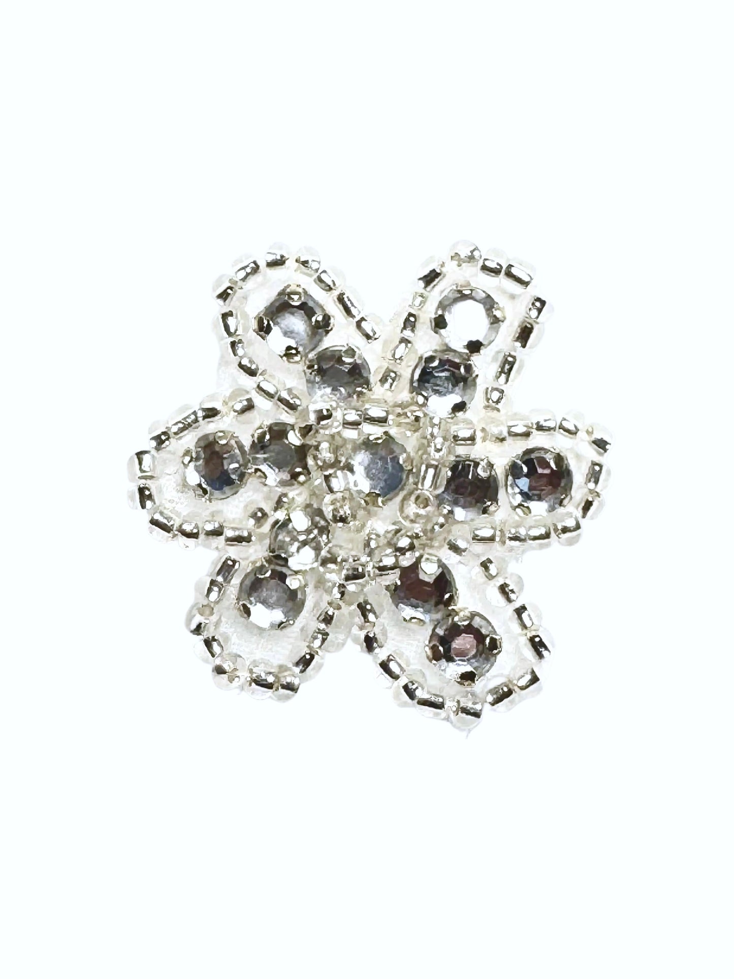 Beaded and rhinestone silver and clear flower on a white background