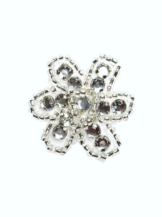 Beaded and rhinestone silver and clear flower on a white background