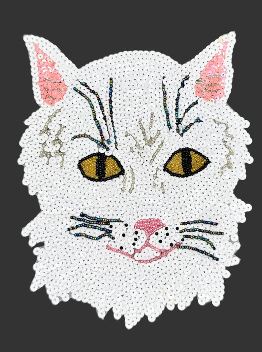 White sequin cat face with sequins and beads on a dark background