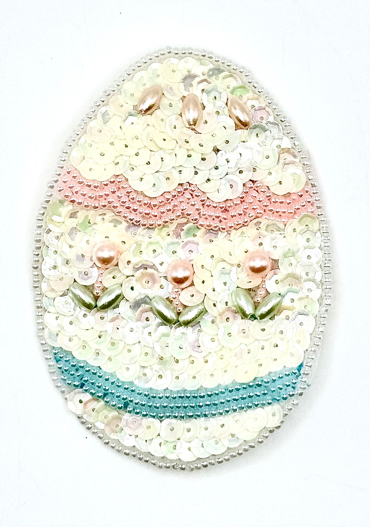 Decorative Easter egg with sequins and beads on a white background