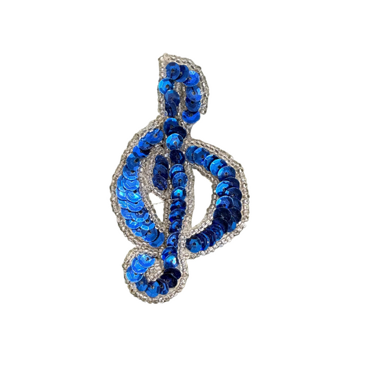 A blue sequined treble clef patch with a silver glass bead border, placed on a white surface.