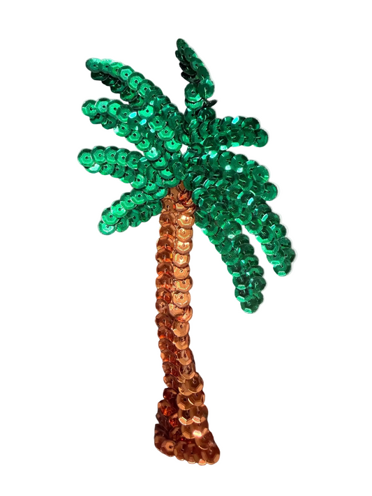 A sequined palm tree appliqué with a green sequin frond and a copper-orange sequin trunk, shown on a textured gray background.