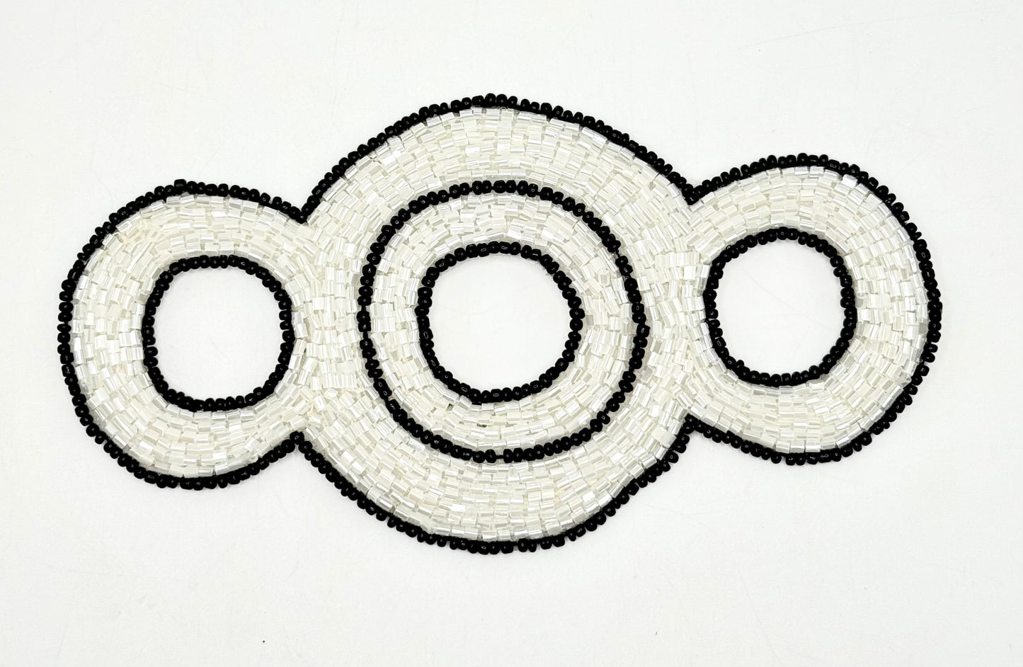 Decorative beaded accent with interlocking circular patterns on a white background