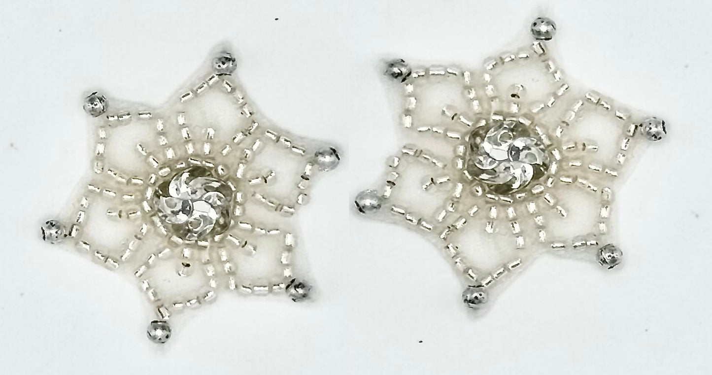Two silver beaded snowflake-shaped patches with silver sequin centers, displayed on a plain white background.
